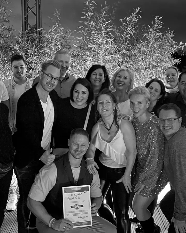Daniel Girten mit seinem Team – Gruppenfoto auf einer Dachterrasse